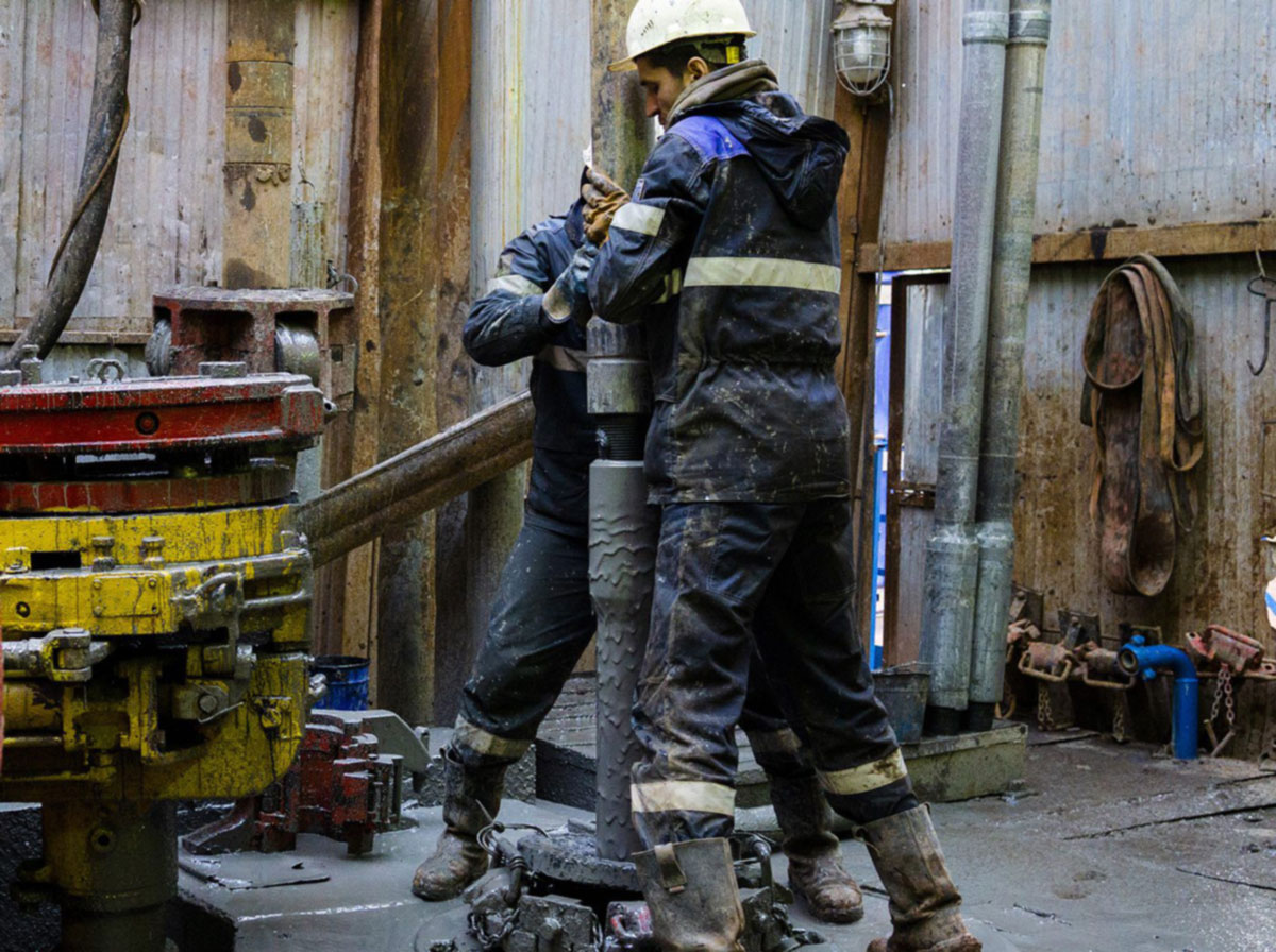 Two people working at an oil rig.