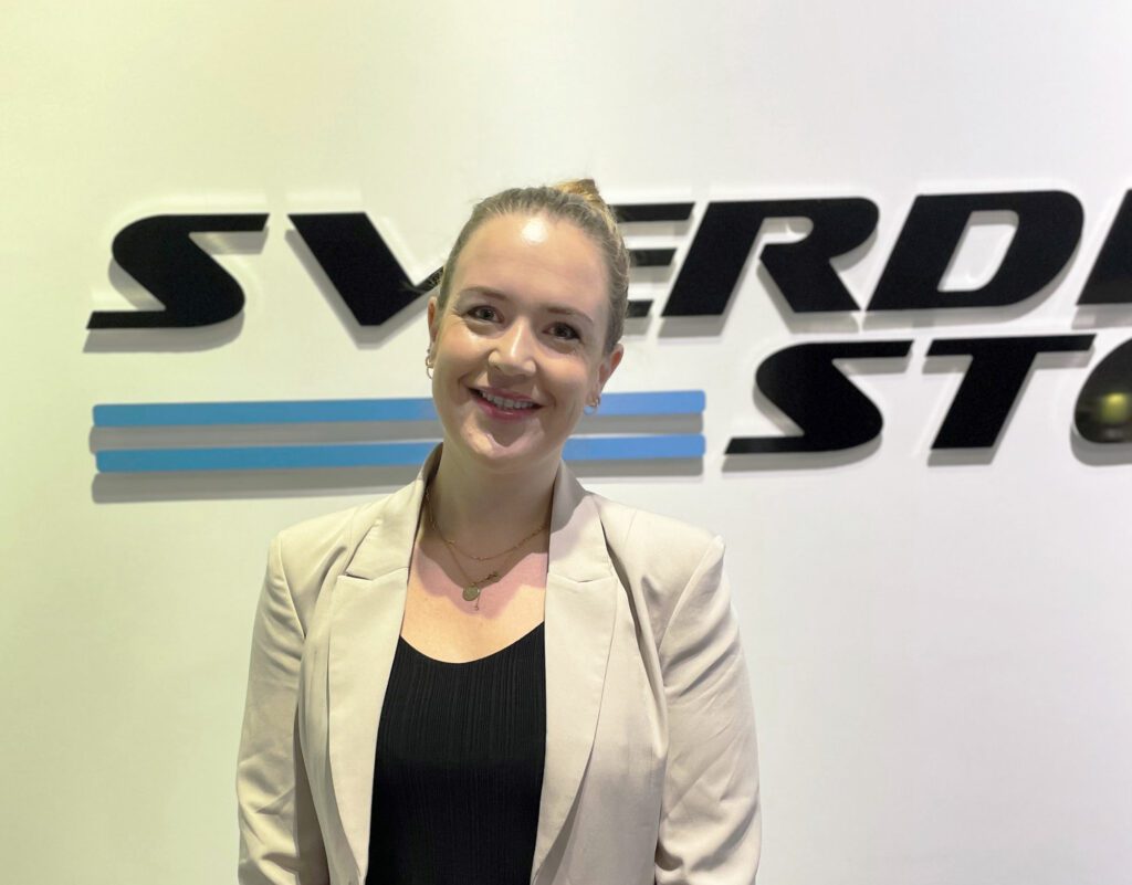 Christine Haugland in front of the Sverdrup Steel logo