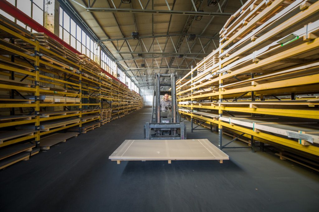 Worker driving a forklift in a warehouse.